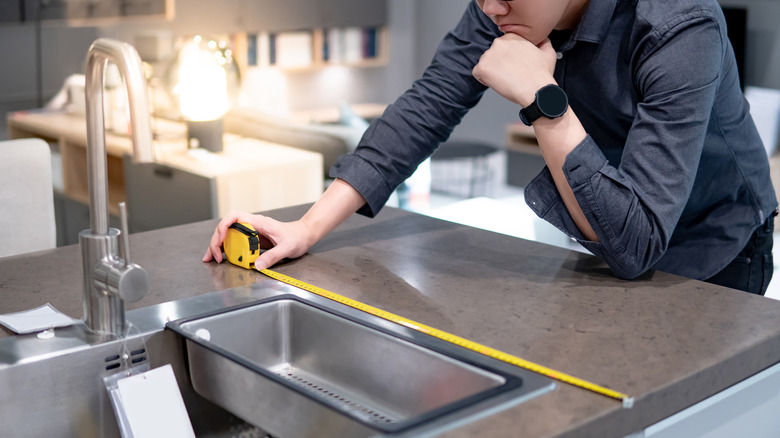 Man measuring laminate countertop