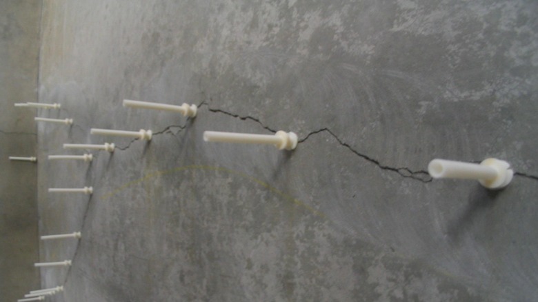 White epoxy injection points along a concrete crack