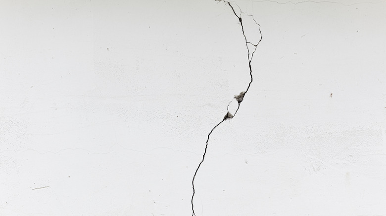 A long crack in a white concrete wall