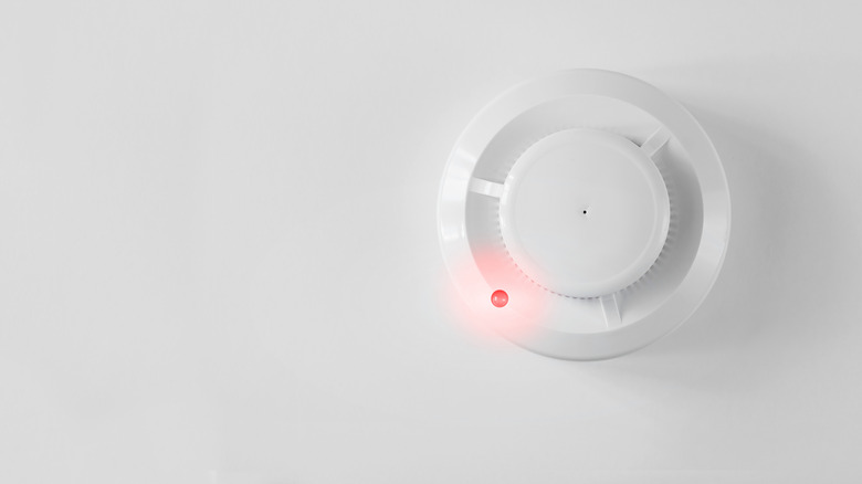 A smoke alarm's red light is on.
