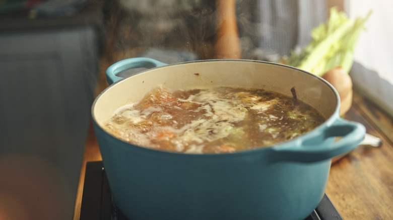 enamel coated pot on stove with soup inside