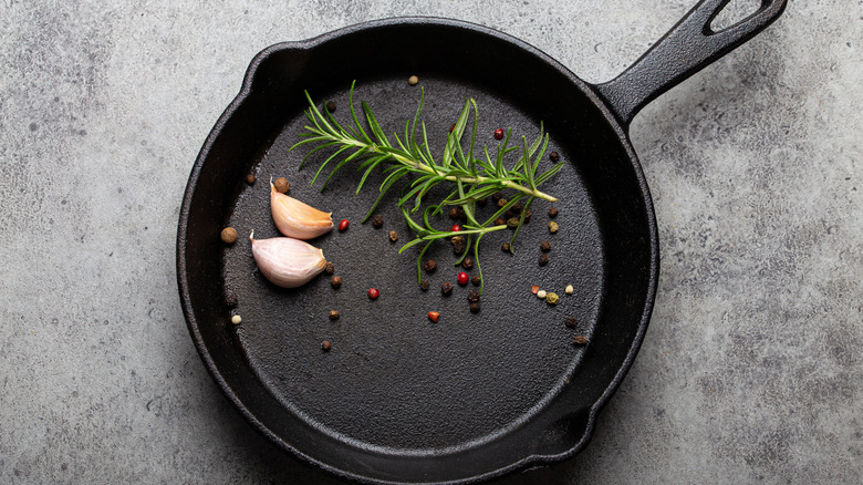 cast iron pan with garlic and herbs inside