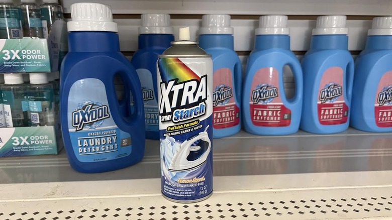 Capless spray starch on Dollar Tree metal shelf beside laundry products