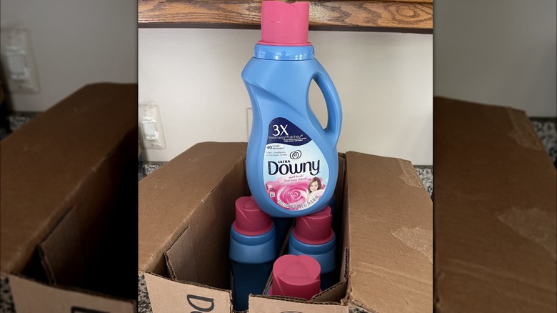 Four unboxed Downy 10 ounce fabric softener bottles