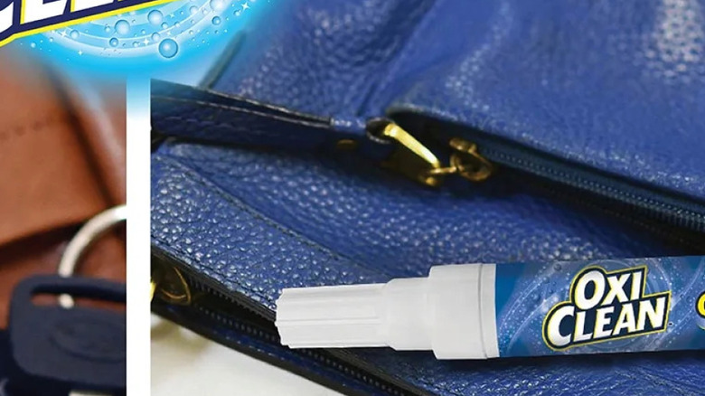Mini OxiClean stain remover on-the-go pen sticking out of blue pleather purse pocket