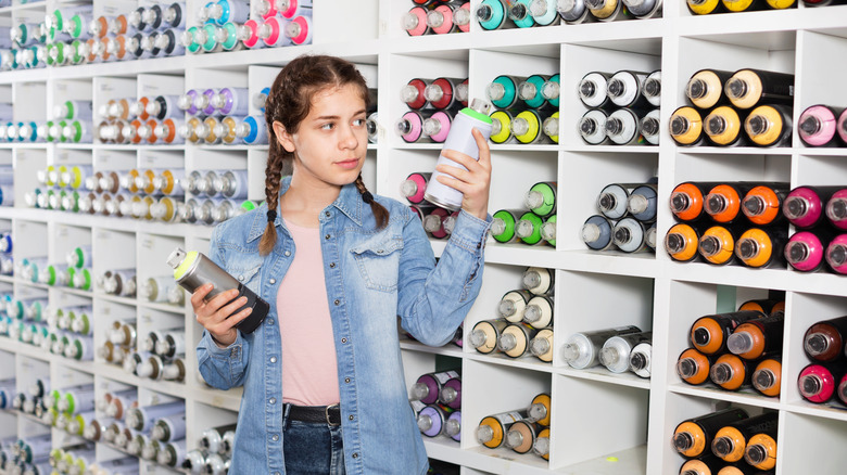 person choosing spray paint in store