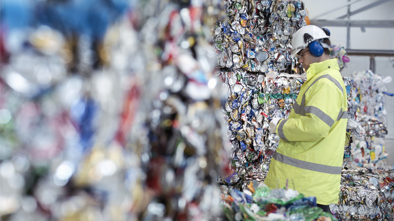 Aluminum cans compressed and stacked with recycling plant employee