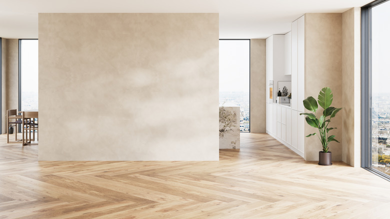 A large, open-plan room with herringbone wood flooring