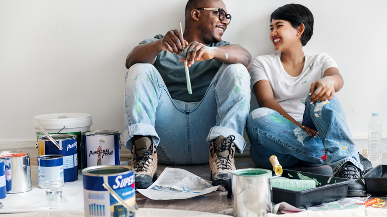 Couple painting a wall together