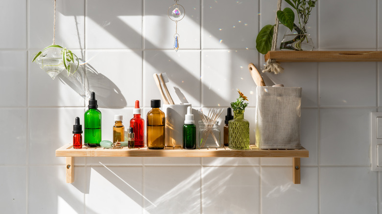 Decanted toiletries in colorful glass jars on bathroom shelf
