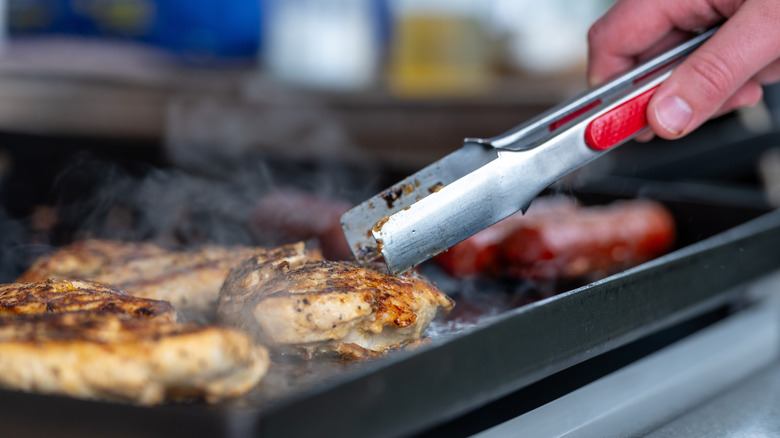 Person making chicken on a Blackstone