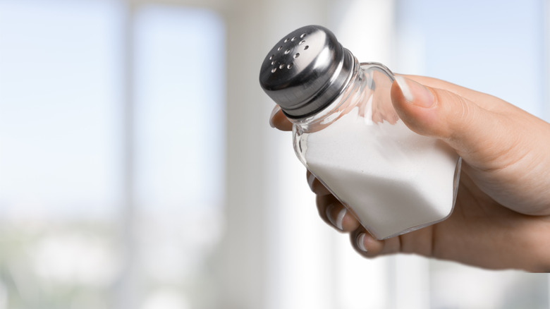 Person holding a salt shaker