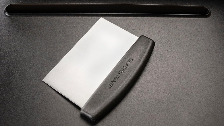 A Blackstone metal scraper on a griddletop