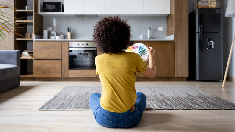 A person selecting paint colors for a kitchen