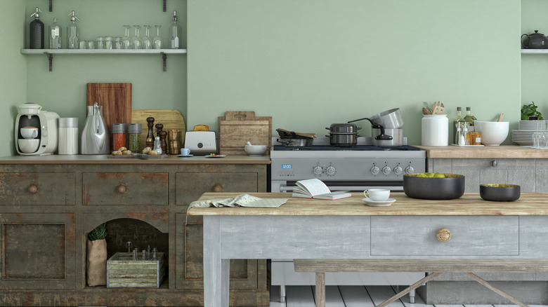 A rustic kitchen with light green walls.