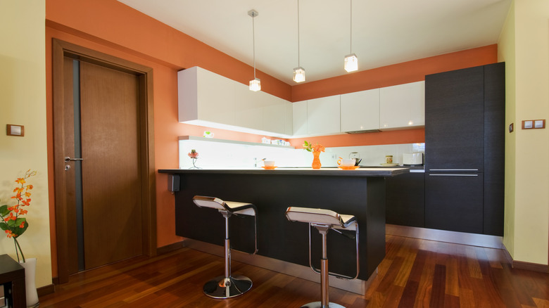 A modern kitchen with orange walls