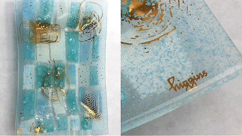 Split image of a light blue glass ashtray with gold accents, and a close-up of the Higgins mark