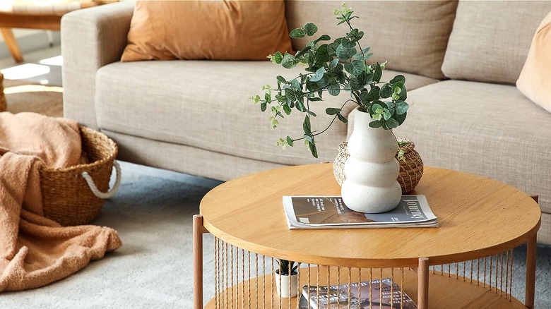 A simple living room set up with a couch and a wood coffee table with basic décor
