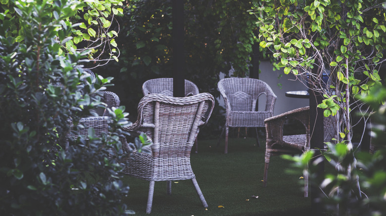 Wicker rattan outdoor chairs in a garden.
