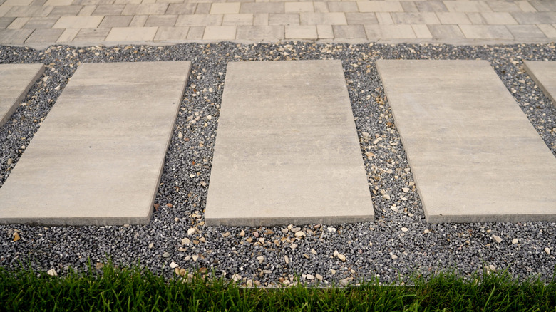 A pathway with concrete pavers and gravel.