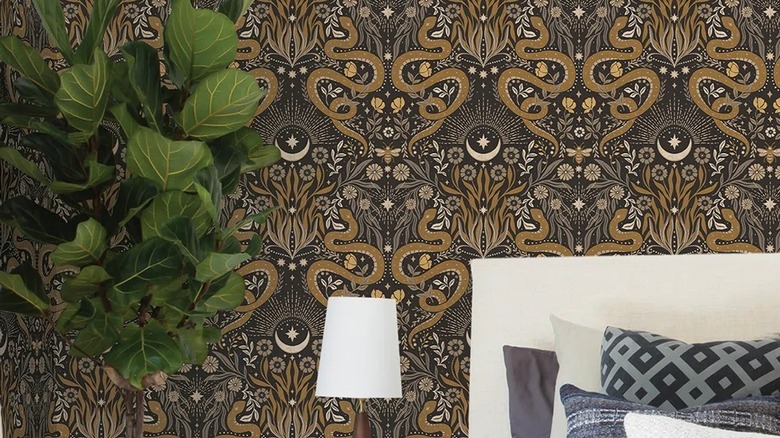 Serpent brown and orange wallpaper in a bedroom with a green plant and lamp