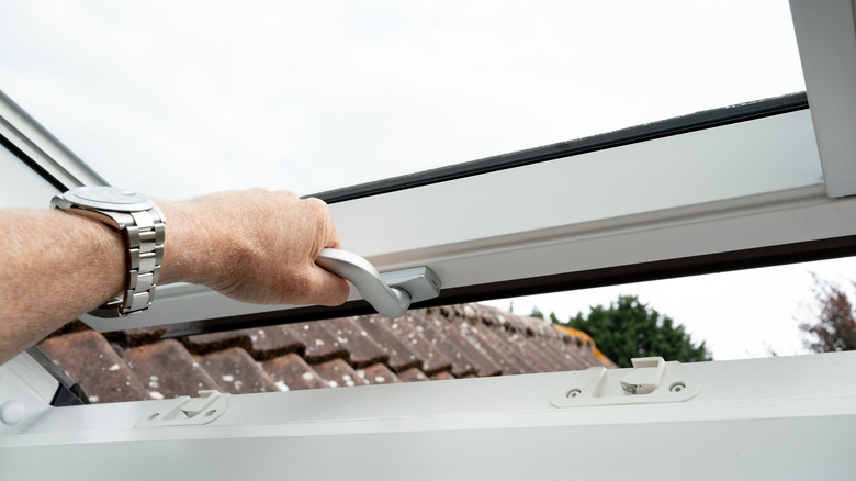 man opening skylight window