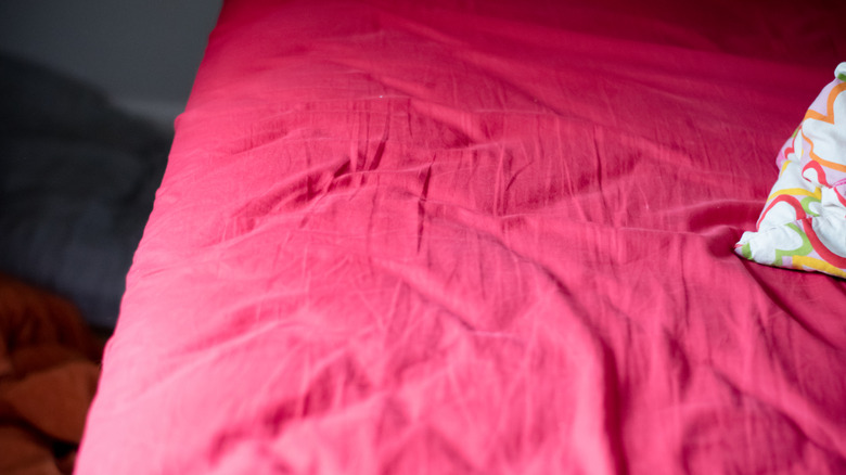 A bed with bring pink sheets