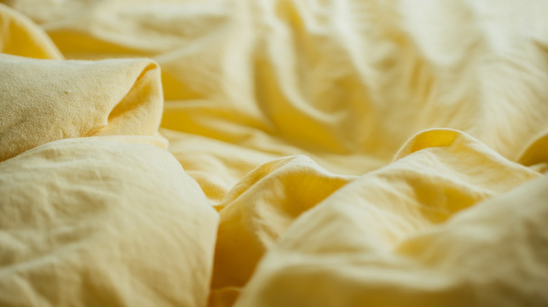 Crumpled yellow bedsheets