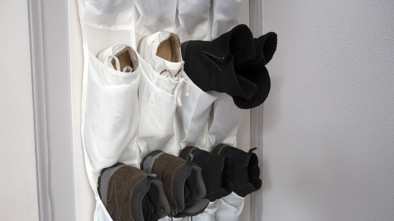 A hanging shoe rack with shoes in it hanging on a door