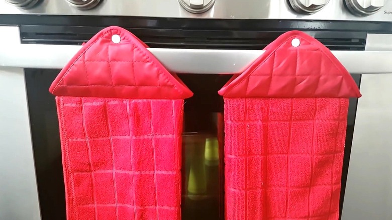 Two red tea towels hang from oven door.