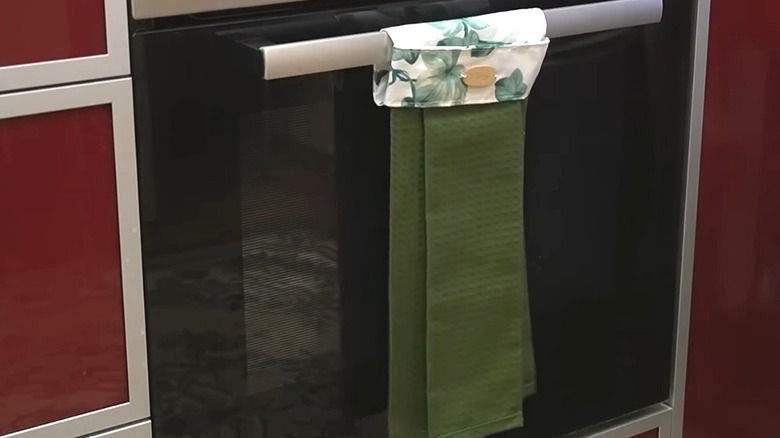 Green tea towel hangs from oven door.