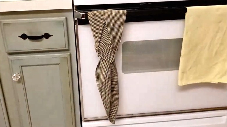Tea towel hangs from oven door.