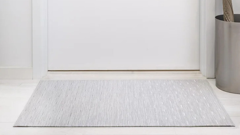 A basic rug in front of a door.