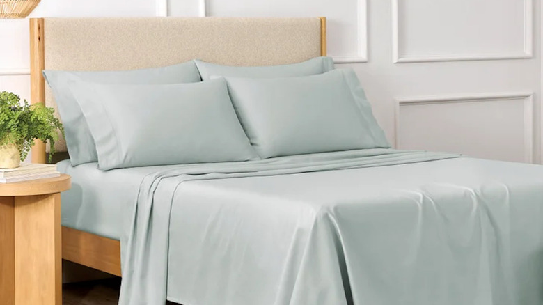 A bed made up with a blue sheet set.