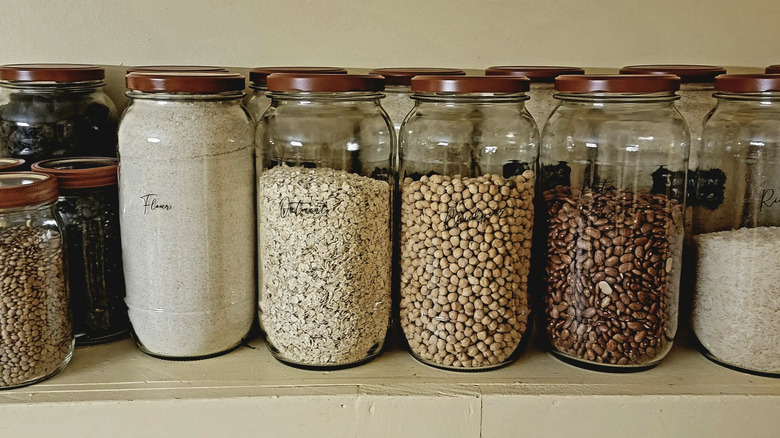 Pickle jars with labels holding dry goods like flour, beans, and oatmeal