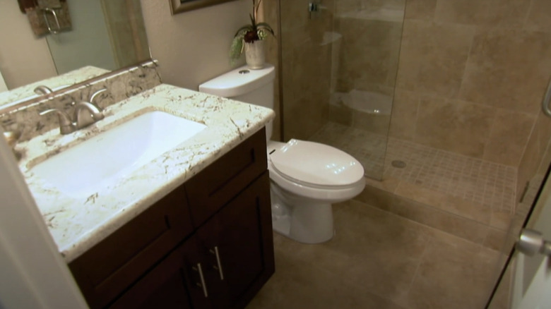 A dated bathroom with beige tiles.