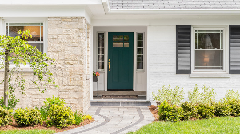 Light brick house with dark green door