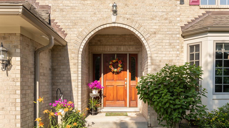 Brick house wooden door floral wreath