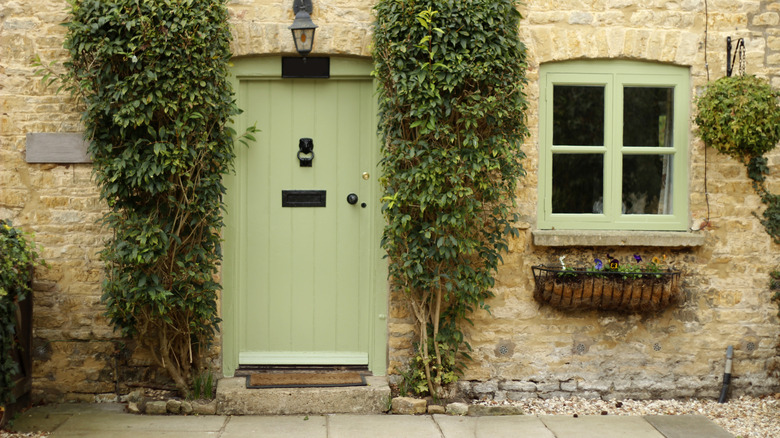 Sage green front door on brick house