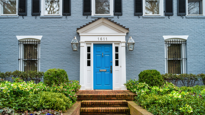 Grey brick house with bright blue door