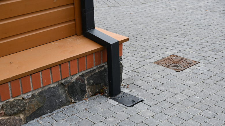 Close up of downspout covered in black wood cover