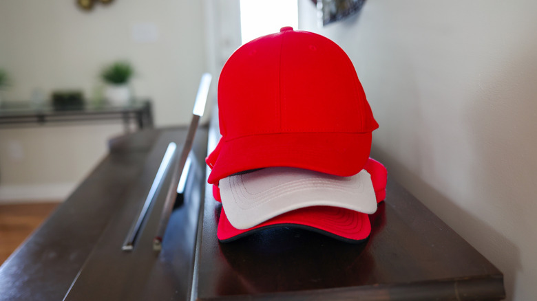 Stack of red and white baseball hats