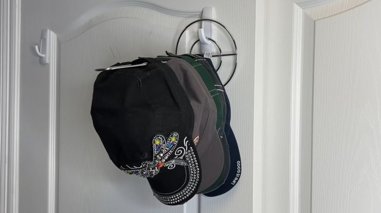 Hats stored on a mounted paper towel holder