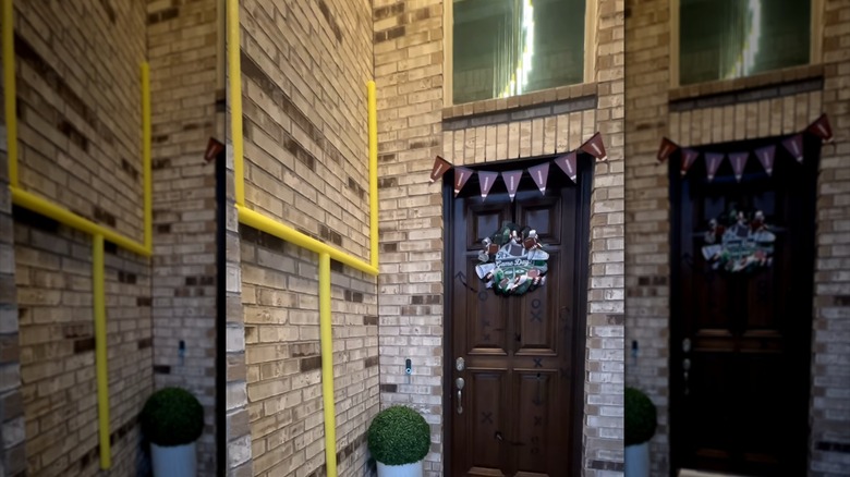 Pool noodles are glued onto a brick exterior to create the look of a football field goal post