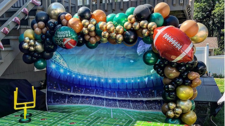 A football-themed pool noodle arch outdoors