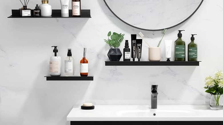 Black floating shelves on a bathroom wall