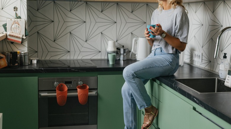 Woman sitting on kitchen counter