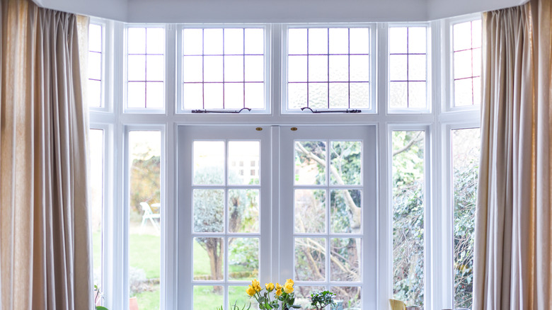 Tall windows with beige curtains