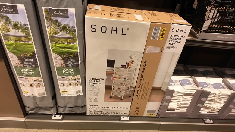 View of the Aldi Finds aisle with a rolling storage cart, packs of dish cloths, and an instant canopy