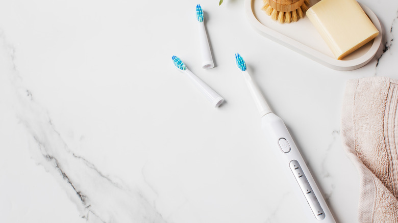 An ultrasonic toothbrush with spare heads on a bathroom counter